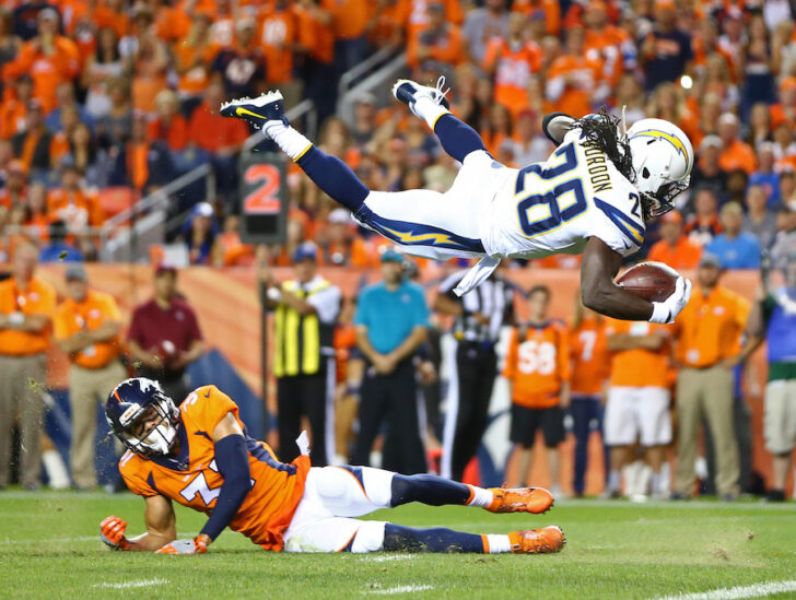 Los Angeles Chargers running back Melvin Gordon (31) leaps over Denver Broncos safety Justin Simmons (31) to score in the second quarter at Sports Authority Field.