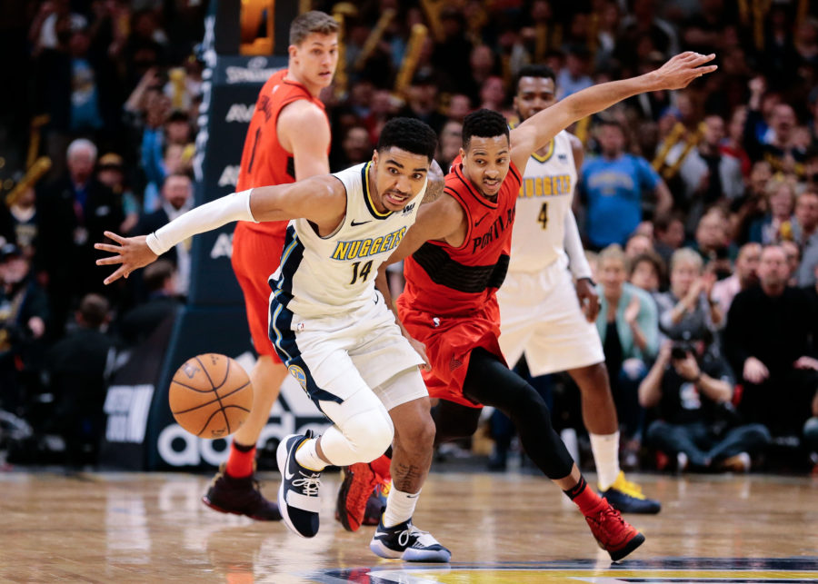 Denver Nuggets guard Gary Harris (14) and Portland Trail Blazers guard CJ McCollum (3) battle for a loose ball in the fourth quarter at the Pepsi Center.