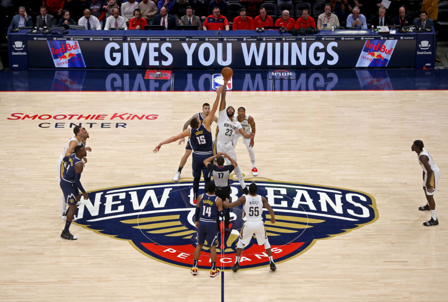 Denver Nuggets center Nikola Jokic (15) jumps with New Orleans Pelicans forward Anthony Davis (23) to start the game at the Smoothie King Center.