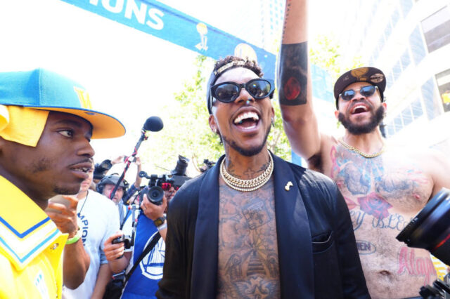 Golden State Warriors guard Nick Young (middle) and center JaVale McGee (right) celebrate during the championship parade in downtown Oakland.