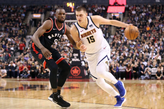 Denver Nuggets center Nikola Jokic (15) drives past Toronto Raptors forward Serge Ibaka (9) in the second quarter at Scotiabank Arena.