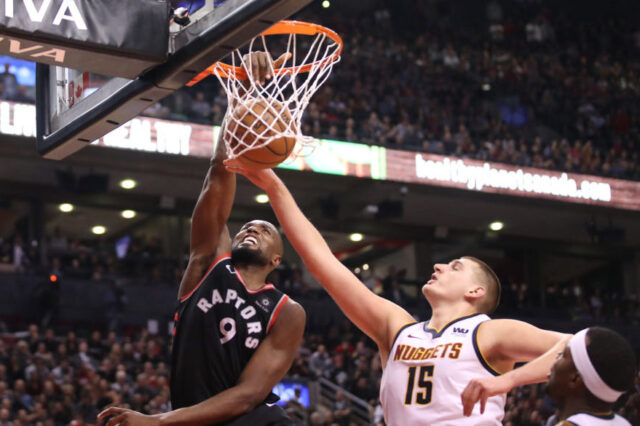 Toronto Raptors forward Serge Ibaka (9) dunks to tie the game in the fourth quarter against Denver Nuggets center Nikola Jokic (15) at Scotiabank Arena. The Nuggets beat the Raptors 106-103.