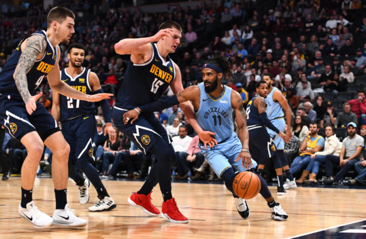 Memphis Grizzlies guard Mike Conley (11) drives at Denver Nuggets forward Juan Hernangomez (41) and center Nikola Jokic (15) in the second half at the Pepsi Center.