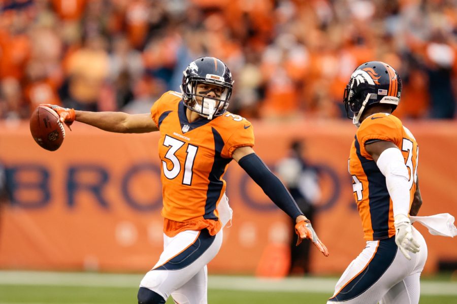 Denver Broncos strong safety Justin Simmons (31) celebrates with safety Will Parks (34) after an interception in the fourth quarter against the Oakland Raiders at Sports Authority Field at Mile High.