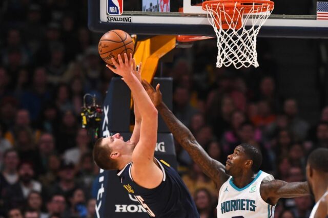 Charlotte Hornets forward Marvin Williams (2) reaches for the ball over Denver Nuggets center Nikola Jokic (15) in the second half at the Pepsi Center.