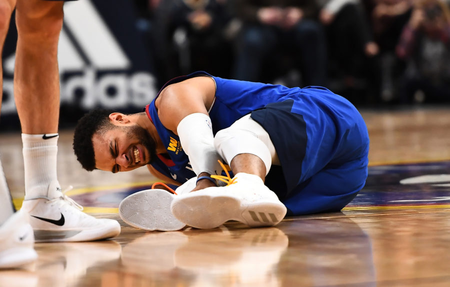 Denver Nuggets guard Jamal Murray (27) lays injured on the court in the fourth quarter against the San Antonio Spurs at the Pepsi Center.