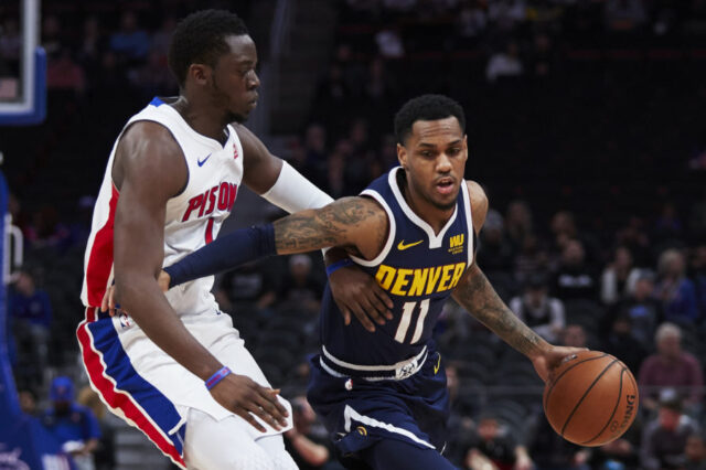 Denver Nuggets guard Monte Morris (11) dribbles the ball defended by Detroit Pistons guard Reggie Jackson (1) in the first half at Little Caesars Arena.