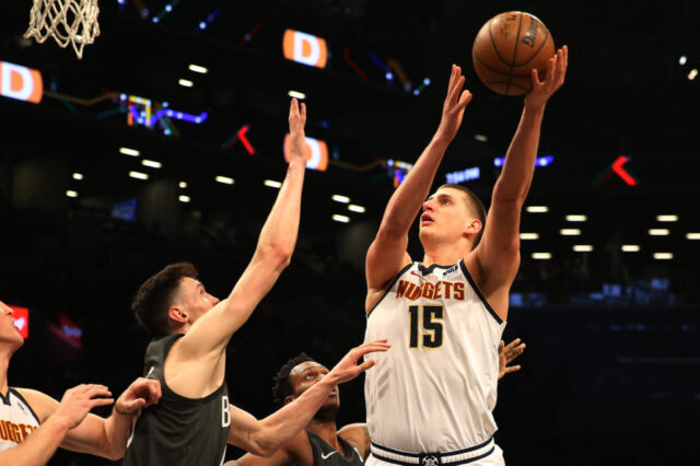 Denver Nuggets center Nikola Jokic (15) shoots against Brooklyn Nets forward Rodions Kurucs (00) during the first half at Barclays Center.