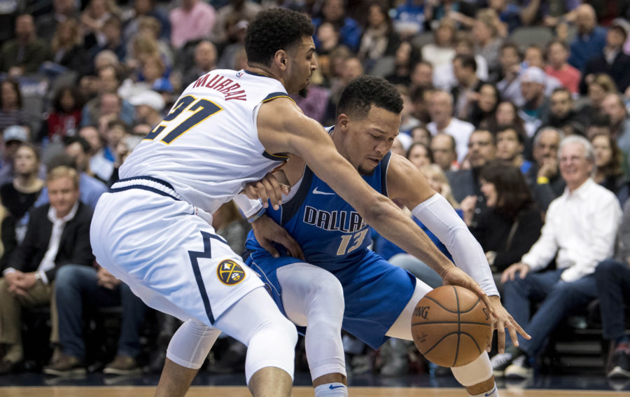 Denver Nuggets guard Jamal Murray (27) and Dallas Mavericks guard Jalen Brunson (13) fight for the loose ball during second quarter at the American Airlines Center.