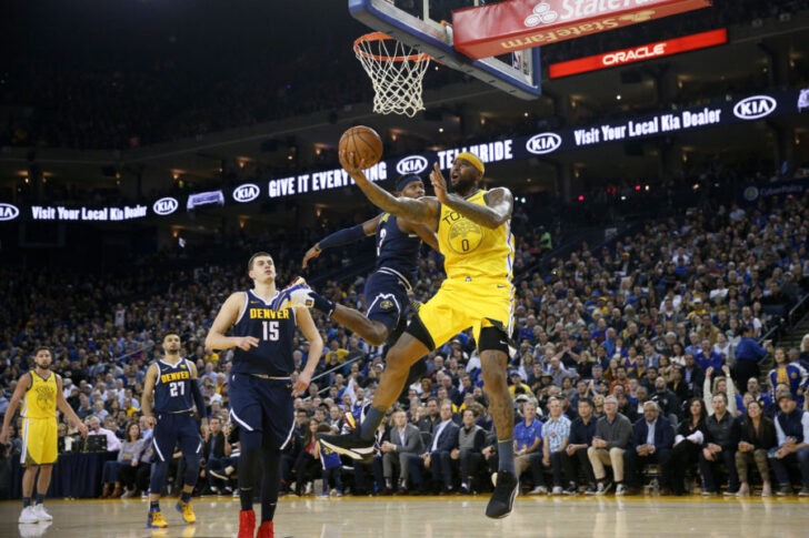 Golden State Warriors center DeMarcus Cousins (0) makes a layup next to Denver Nuggets forward Torrey Craig (3) in the second quarter at Oracle Arena.