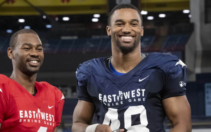 Justin Hollins (right) receives an award as the defensive MVP of the East-West Shrine Game.