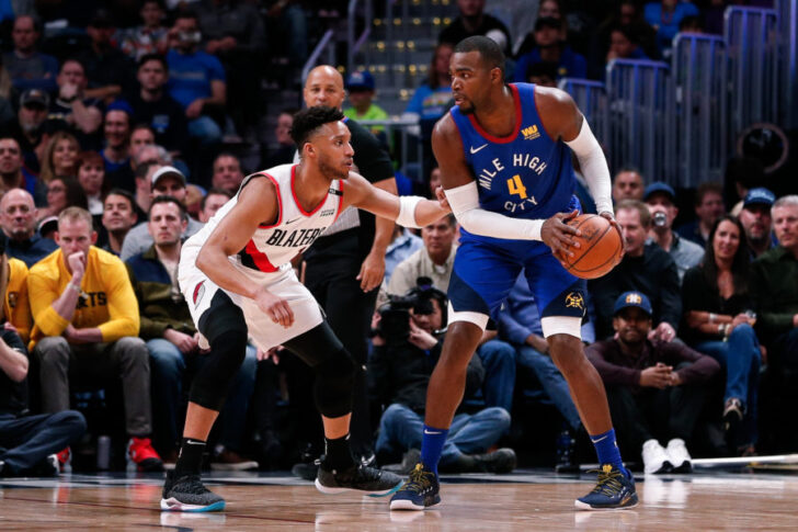 Denver Nuggets forward Paul Millsap (4) controls the ball as Portland Trail Blazers guard Evan Turner (1) defends in the first quarter at the Pepsi Center.