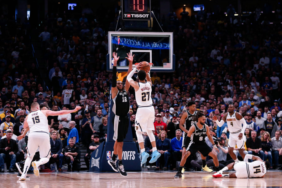 Denver Nuggets guard Jamal Murray (27) attempts a shot against San Antonio Spurs center LaMarcus Aldridge (12) as center Nikola Jokic (15) looks on and guard Patty Mills (8) and forward Rudy Gay (22) defend against guard Gary Harris (14) and forward Paul Millsap (4) in the fourth quarter in game two of the first round of the 2019 NBA Playoffs at the Pepsi Center.