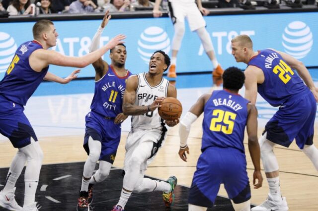 San Antonio Spurs shooting guard DeMar DeRozan (10) drives for the basket between Denver Nuggets point guard Monte Morris (11) and Malik Beasley (25) in game four of the first round of the 2019 NBA Playoffs at AT&T Center.