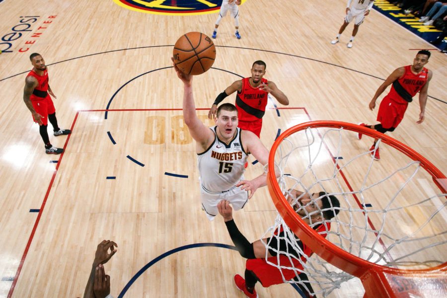 Denver Nuggets center Nikola Jokic (15) drives to the net against Portland Trail Blazers center Enes Kanter (00) and guard Rodney Hood (5) in the fourth quarter in game two of the second round of the 2019 NBA Playoffs at the Pepsi Center.