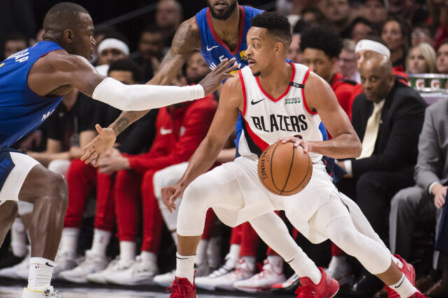 Portland Trail Blazers guard CJ McCollum (3) controls the ball as Denver Nuggets forward Paul Millsap (4) and guard Will Barton (5) defend during the first half in game six of the second round of the 2019 NBA Playoffs at Moda Center.