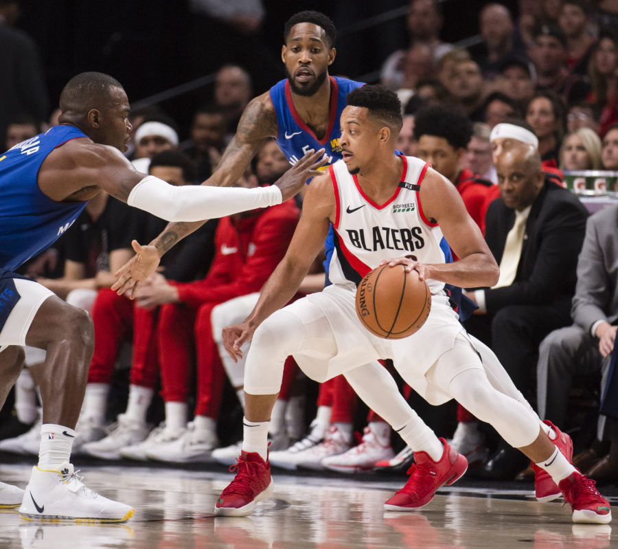 Portland Trail Blazers guard CJ McCollum (3) controls the ball as Denver Nuggets forward Paul Millsap (4) and guard Will Barton (5) defend during the first half in game six of the second round of the 2019 NBA Playoffs at Moda Center.