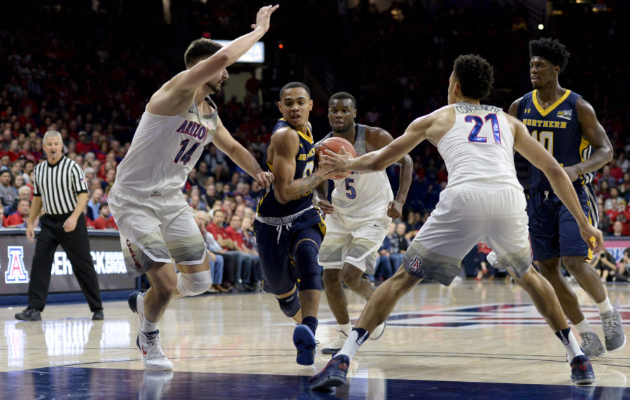 Northern Colorado Bears guard Jordan Davis (0) drives to the basket as Arizona Wildcats center Dusan Ristic (14) and center Chance Comanche (21) defends during the