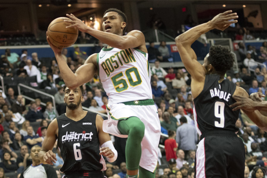 Boston Celtics guard PJ Dozier (50) shoots in between Washington Wizards guard Chasson Randle (9) and forward Troy Brown Jr. (6) during the second quarterat Capital One Arena.