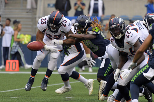 Seattle Seahawks outside linebacker Shaquem Griffin (49) forces a fumble by Denver Broncos running back Devontae Booker (23) in the first quarter at CenturyLink Field.