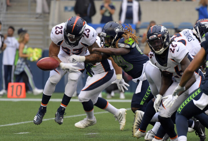 Seattle Seahawks outside linebacker Shaquem Griffin (49) forces a fumble by Denver Broncos running back Devontae Booker (23) in the first quarter at CenturyLink Field.