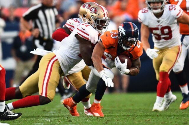 San Francisco 49ers defensive tackle Jullian Taylor (71) tackles Denver Broncos running back Devontae Booker (23) in the second quarter at Broncos Stadium at Mile High.