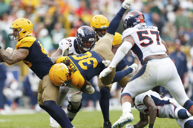 Green Bay Packers running back Jamaal Williams (30) is tackled by Denver Broncos defensive end Adam Gotsis (99) and defensive end DeMarcus Walker (57) during the fourth quarter at Lambeau Field.