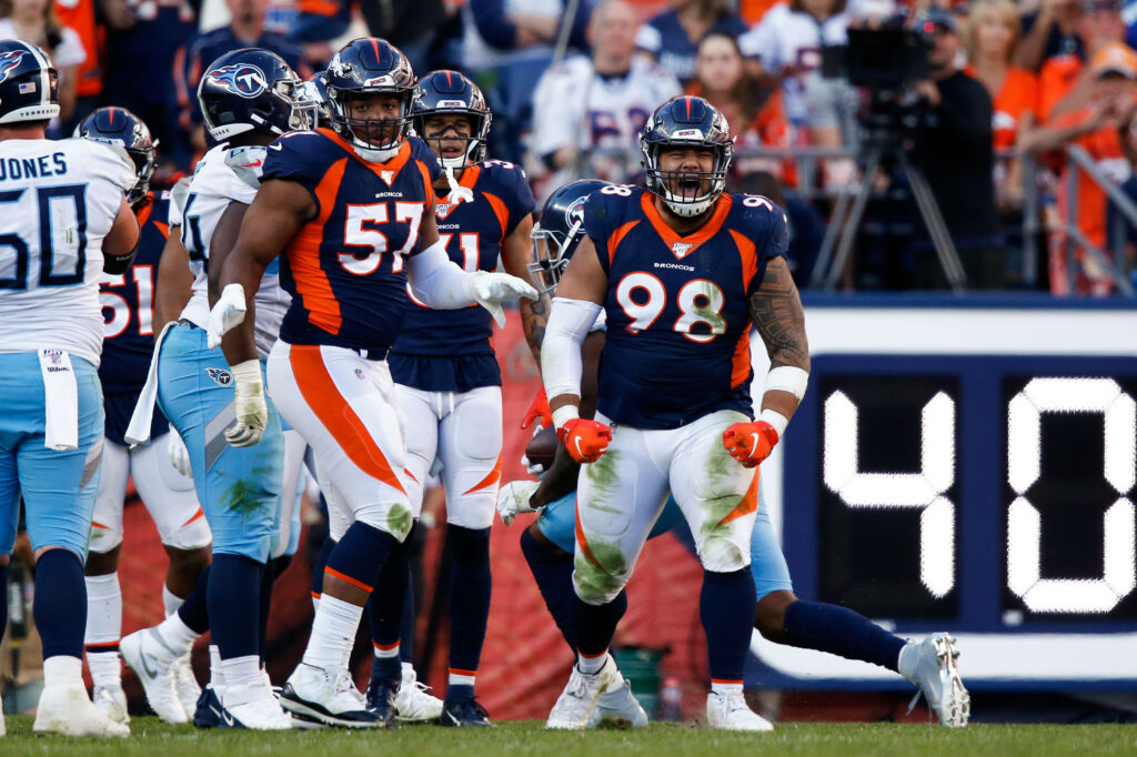 Denver Broncos nose tackle Mike Purcell (98) reacts after a play as defensive end DeMarcus Walker (57) looks on in the fourth quarter against the Tennessee Titans at Empower Field at Mile High.