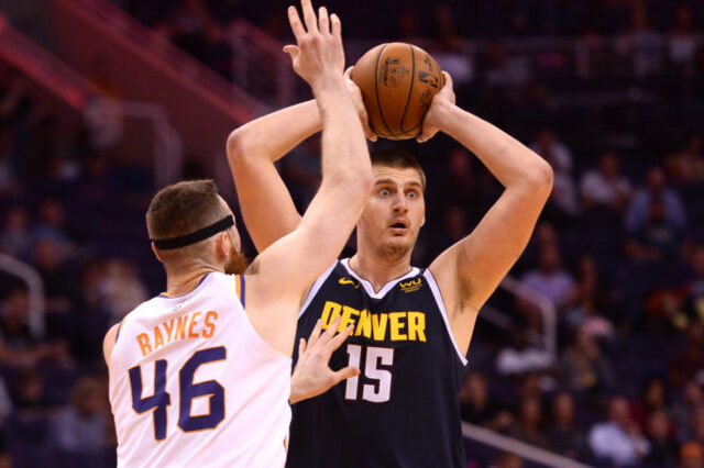 Denver Nuggets center Nikola Jokic (15) controls the ball against Phoenix Suns center Aron Baynes (46) during the second half at Talking Stick Resort Arena.