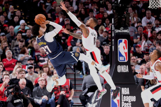 Portland Trail Blazers guard Damian Lillard (0) defends Denver Nuggets guard Jamal Murray (27) in the second half at Moda Center.