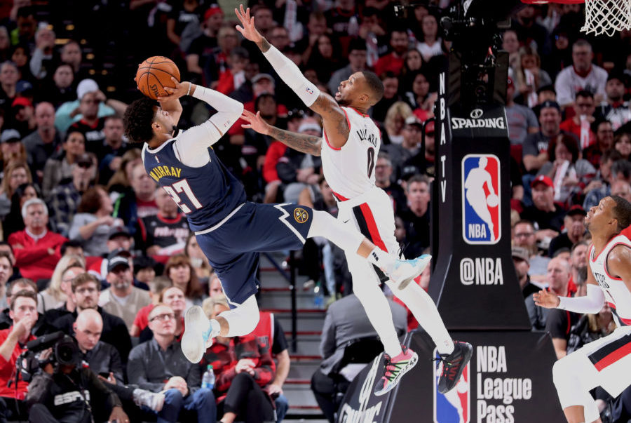 Portland Trail Blazers guard Damian Lillard (0) defends Denver Nuggets guard Jamal Murray (27) in the second half at Moda Center.