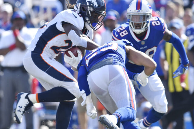 Orchard Park, NY, USA; Denver Broncos running back Jamaal Charles (28) looks to avoid a tackle by Buffalo Bills strong safety Micah Hyde (23) and cornerback E.J. Gaines (28) during the third quarter of a game at New Era Field.