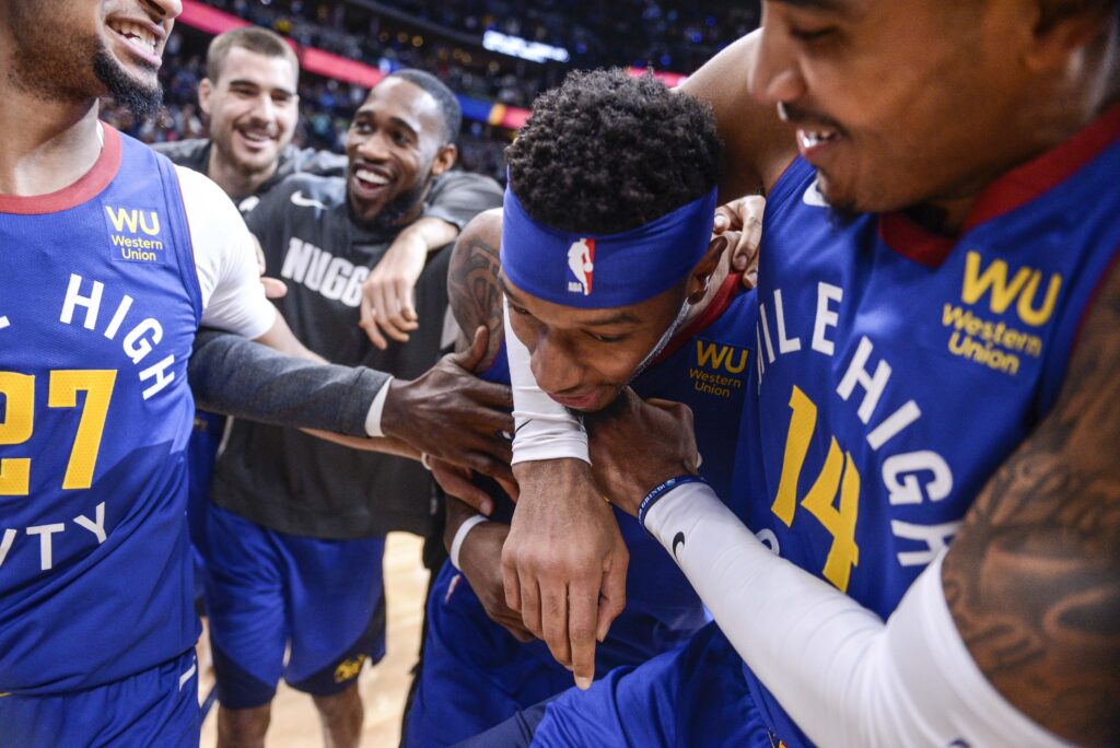 Denver Nuggets guard Gary Harris (14) hugs forward Torrey Craig (3), who blocked a shot to win the game against the Phoenix Suns in overtime at Pepsi Center.