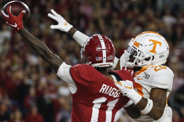 Henry Ruggs catches a pass with a defender draped on his back. Credit: Butch Dill, USA TODAY Sports.