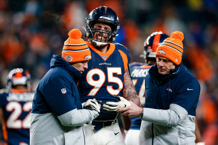 Denver Broncos defensive end Derek Wolfe (95) is helped off the field in the fourth quarter against the Los Angeles Chargers at Empower Field at Mile High.