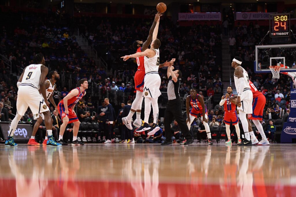 Detroit Pistons center Andre Drummond (0) and Denver Nuggets center Nikola Jokic (15) during the opening tip off at Little Caesars Arena.