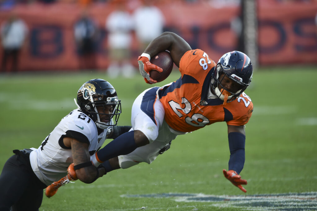 Jacksonville Jaguars cornerback A.J. Bouye (21) (left) tackle Denver Broncos running back Royce Freeman (28) at Empower Field at Mile High.