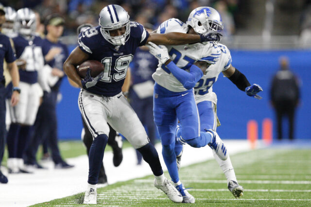 Dallas Cowboys wide receiver Amari Cooper (19) stiff arms Detroit Lions cornerback Justin Coleman (27) after a catch during the fourth quarter at Ford Field.