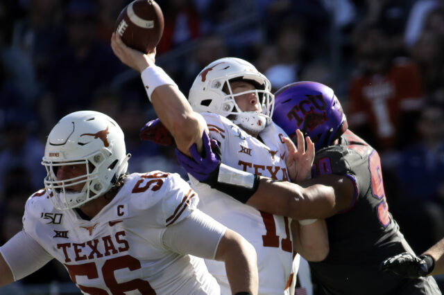 Texas Longhorns quarterback Sam Ehlinger (11) is hit by TCU Horned Frogs defensive tackle Ross Blacklock (90) during the second quarter at Amon G. Carter Stadium.