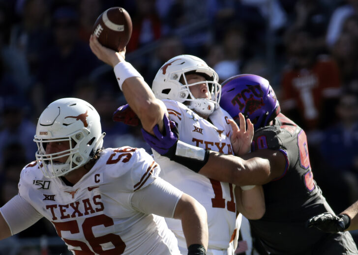 Texas Longhorns quarterback Sam Ehlinger (11) is hit by TCU Horned Frogs defensive tackle Ross Blacklock (90) during the second quarter at Amon G. Carter Stadium.