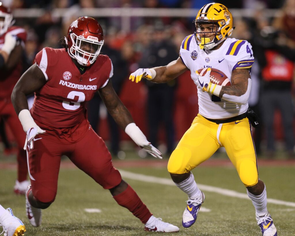 LSU Tigers running back Nick Brossette (4) rushes as Arkansas Razorbacks defensive lineman McTelvin Agim (3) defends in the first quarter at Donald W. Reynolds Razorback Stadium.