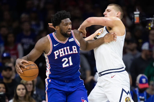 Philadelphia 76ers center Joel Embiid (21) controls the ball against Denver Nuggets center Nikola Jokic (15) during the second quarter at Wells Fargo Center.