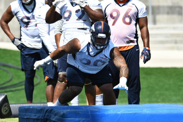 Denver Broncos nose tackle Kyle Peko (90) dives during mini camp drills at the UCHealth Training Center.