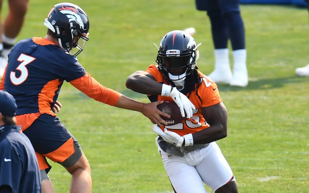 Drew Lock hands off to Melvin Gordon. Credit: Ron Chenoy, USA TODAY Sports.