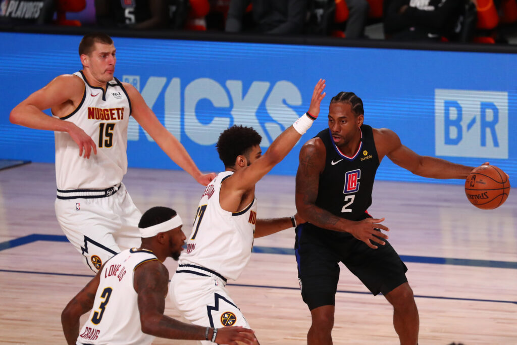 LA Clippers forward Kawhi Leonard (2) dribbles the ball against Denver Nuggets guard Jamal Murray (27) during the first half in game one of the second round of the 2020 NBA Playoffs at AdventHealth Arena.