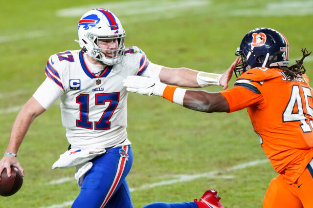 Buffalo Bills quarterback Josh Allen (17) stiff arms Denver Broncos linebacker A.J. Johnson (45) during the third quarter at Empower Field at Mile High.