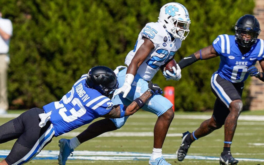 Javonte Williams runs through tackles, like he's known to do. Credit: Jim Dedmon, USA TODAY Sports.