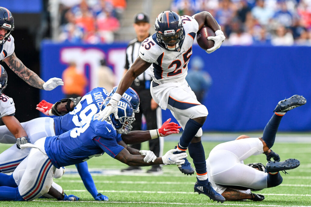 Denver Broncos running back Melvin Gordon (25) leaps over New York Giants linebacker Tae Crowder (48) during the second half at MetLife Stadium.