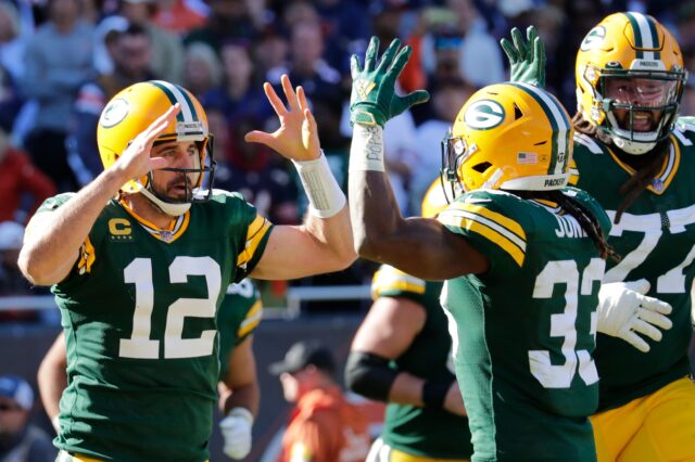 Green Bay Packers quarterback Aaron Rodgers (12) celebrates scoring a touchdown in the fourth quarter with running back Aaron Jones (33) during their football game Sunday, October 17, 2021, at Soldier Field in Chicago, Ill. Green Bay won 24-14.