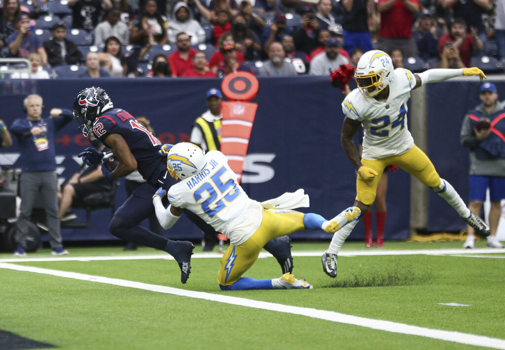 Houston Texans wide receiver Nico Collins (12) scores a touchdown as Los Angeles Chargers cornerback Chris Harris (25) defends during the fourth quarter at NRG Stadium.